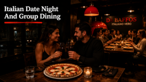 Couple-enjoying-Italian-date-night-with-stone-baked-pizza-while-a-group-dining-experience-takes-place-inside-Da-Baffos-restaurant-in-Clapton.